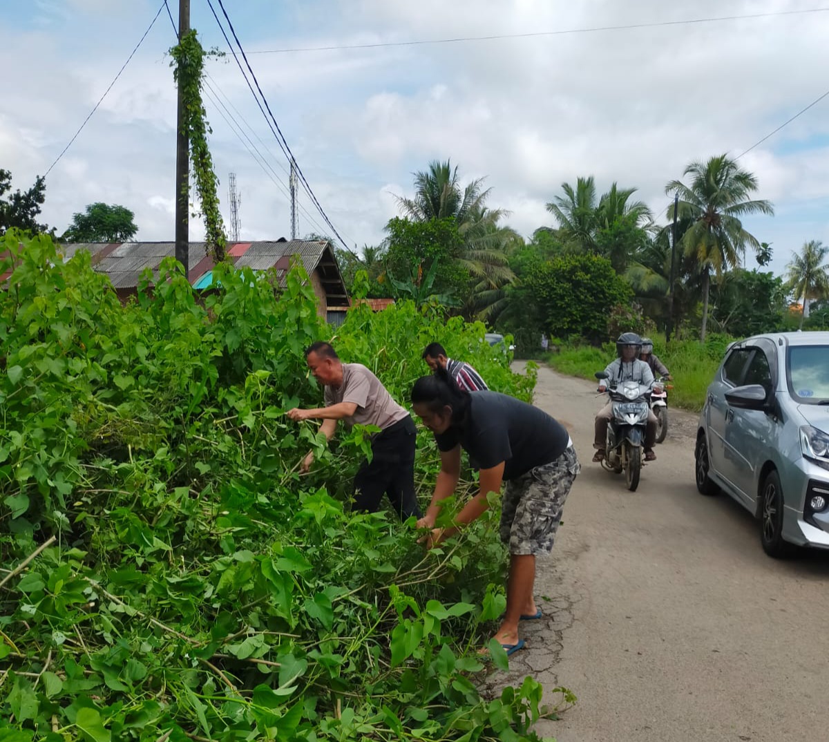 Bersama Masyarakat, Ipda Asmadi Bergotong royong Bersihkan Jalan