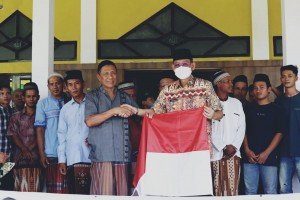 Pj Bupati Pringsewu Bagikan Bendera Merah Putih Kepada Warga